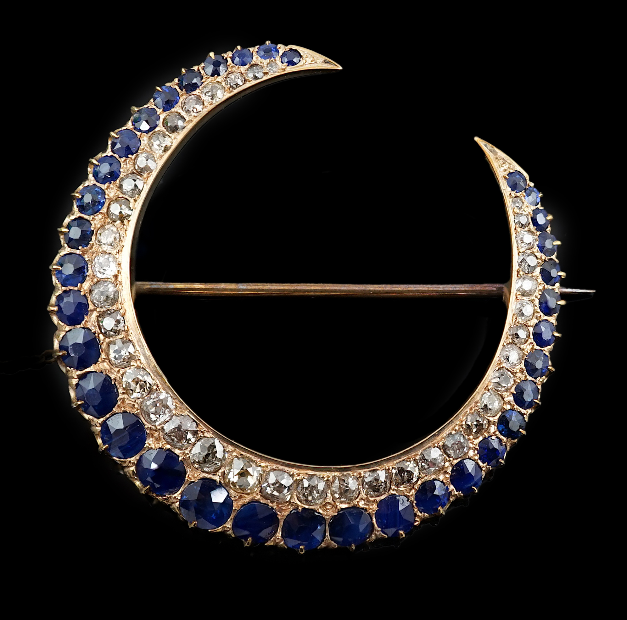 An early to mid 20th century gold, graduated sapphire and graduated diamond set two row crescent brooch